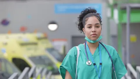 Getty Images Stock photo of a doctor in scrubs leaving a hospital