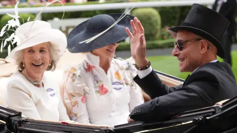 Lady Cavendish (left), Felicity Blunt (centre) and Stanley Tucci arrive by carriage on day three of Royal Ascot at Ascot Racecourse, Berkshire.