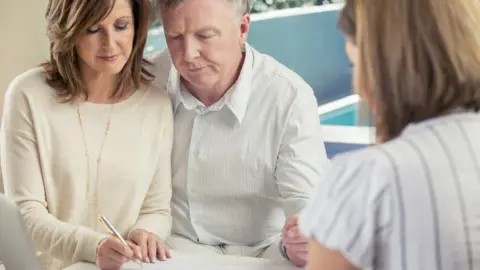 Getty Images Older couple signing papers