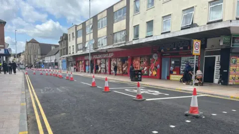 Nicola Haseler/BBC Midland Road in Bedford, showing traffic cones, along the road, cordoning part of it off. People are walking down the road, in the distance.
