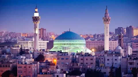 Getty Images A blue domed mosque dominates a city skyline, with two tall minarets either side of the dome.
