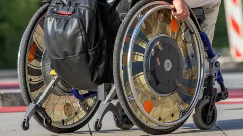Getty Images A generic image of a wheelchair. A man's hand is visible.