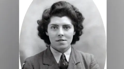 Family handout A young woman with dark, short curly hair, smiles at the camera, wearing an army uniform.