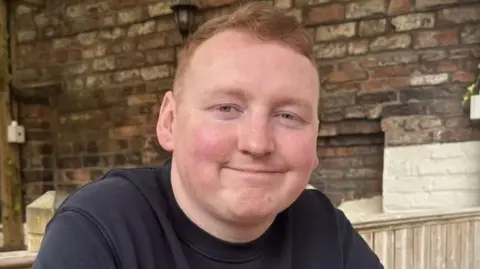 Family handout Andrew Foster, a man with red hair, smiles at the camera