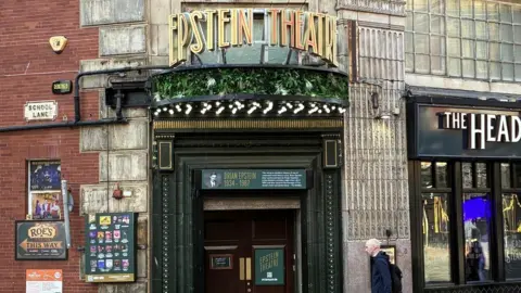 Exterior of the Epstein Theatre with the large art deco sign over its door.