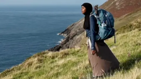 Amina Hassan looks at the sea from the top of a hill