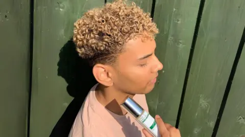 Kyle Frank Kyle holding skincare product