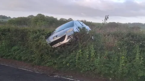 Car overturned in a hedge