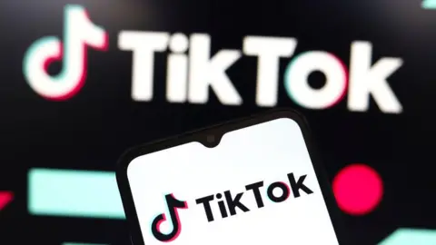 Getty Images TikTok logo displayed on a smartphone, with another blurred in the background behind it.