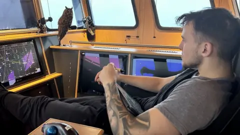 Benarkle II owl and crew member