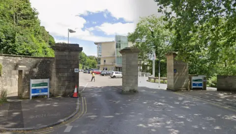 Google The car park entrance to a police car park is pictured, with stone pillars forming the entry and exit junctions.