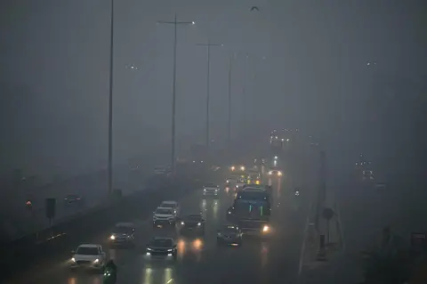 Hindustan Times via Getty Images Vehicle moves amid low visibility due to dense smog on the National Highway-48 near Signature Tower flyover, on December 14, 2025 in Gurugram, India. The national capital, Delhi, on Sunday woke up to a thick layer of smog, with air quality lingering in the 'severe' category. The Central Pollution Control Board (CPCB) recorded the Air Quality Index (AQI) at 462 at 6 am. (Photo by Parveen Kumar/Hindustan Times via Getty Images)