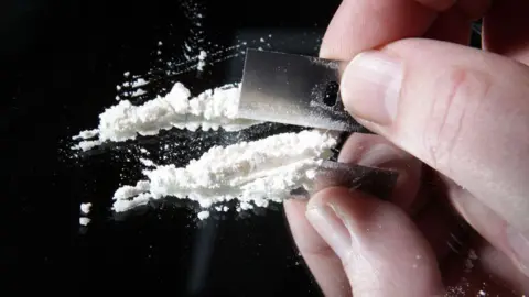 Cocaine being cut into lines with a razor