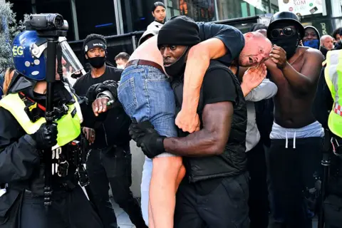 Dylan Martinez / Reuters Patrick Harrison carries a man to safety