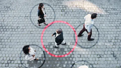 Getty Images Passing pedestrians with circles drawn around each of them to signify transmission of Covid