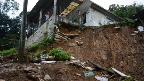 Reuters Mudslide with house on top of an embankment