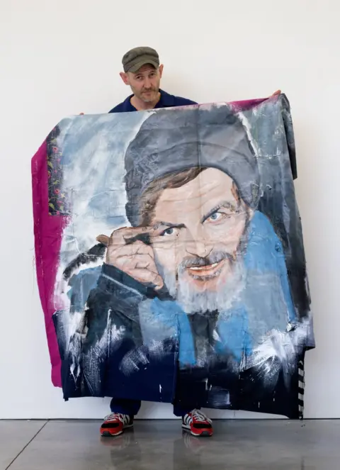 BBC David Tovey holding his artwork