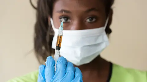 Getty Images A generic photo of a masked nurse holding up a vaccine