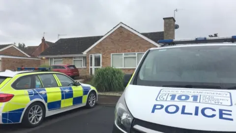 PA Media Police officers searching a house in Kempsey, Worcestershire after female human remains were found in a septic tank on July 12.