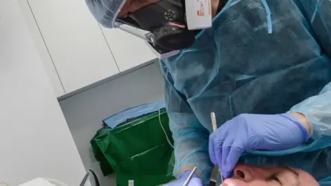 Getty Images Dentist in full PPE