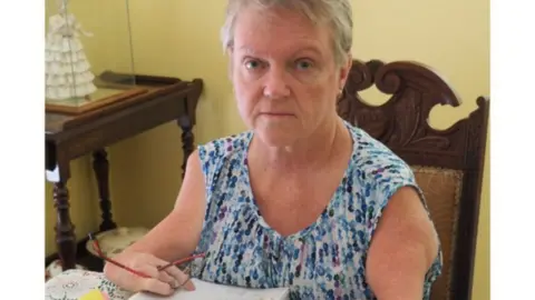 Lisa McManus Lisa McManus holds a pen with her shortened arms as a result of thalidomide