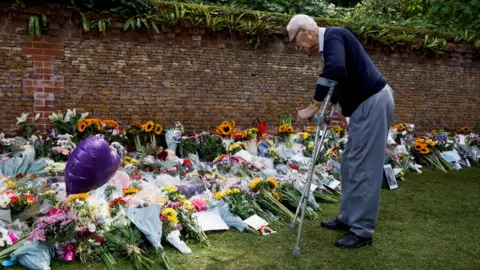 Reuters A man looks at floral tributes left at the Sandringham Estate