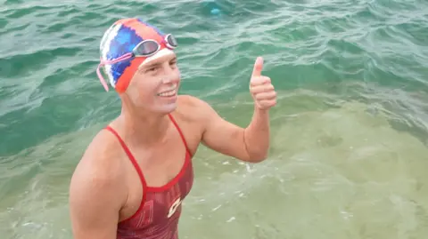 Grace van der Byl wearing swimming gear as she leaves the water in Jersey.
