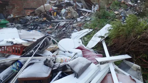 Environment Agency A large pile of rubbish including suitcases, toilet lids and plastic strips