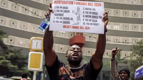 Getty Images A protester holds up a sign during a demonstration against the proposed government tax bill in the Central Business District of Nairobi, Kenya, on Tuesday, June 25, 2024