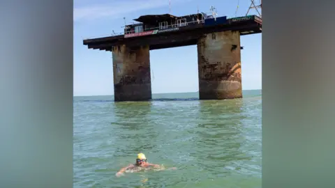 Jon Wills Dani Cameron treads water in the North Sea, having just swam to Sealand, a military fortress off the coast of Suffolk