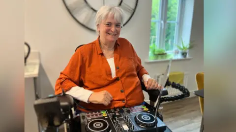Sue, pictured with DJ decks on her lap