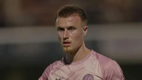 George Nurse standing on the pitch during a match for Shrewsbury Town this season