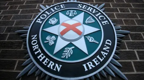 PSNI logo on brick wall