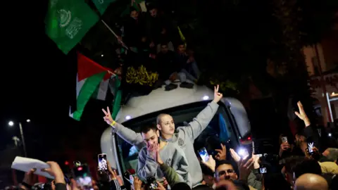 Palestinians gesture after being freed from Israeli prisons as part of the Gaza ceasefire and hostage release agreement in the occupied West Bank (20 January 2025)