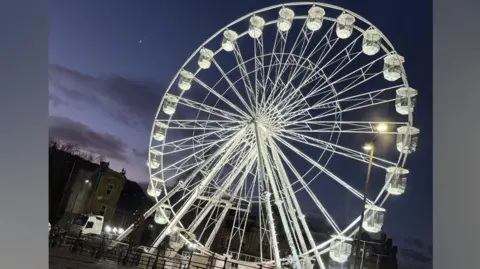 Turners Butchers Darwen Night-time image of the giant, illuminated ferris wheel