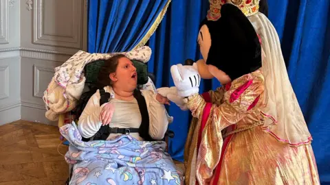 Family 18-year-old Charlotte sitting in her wheelchair during a day out at Disney.