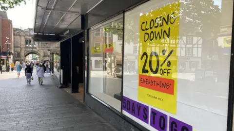 The window of House of Fraser on Lincoln's high street advertises reductions in the run up to the shop's closure