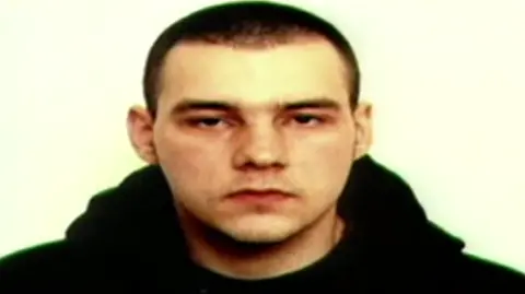 Gwent Police Mugshot of Dylan Watcyns, who wears a black hoodie and looks into the camera. 
