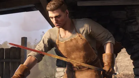 Warhorse Studios A screenshot shows a man wearing thick leather gauntlets and a leather apron holding a glowing-hot piece of long, thin metal, probably intended to become a sword blade.