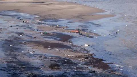 The Greenwich Peninsular foreshore of the Thames river at low-tide, showing hundreds of pieces of litter 