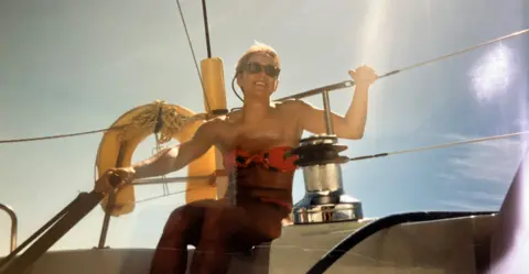 Joanna Brittan, pictured in 1989, relaxing on a yacht in a bikini and sunglasses.