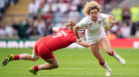 PA Media England's Ellie Kildunne (right) evades a tackle from Canada's Karen Paquin and runs in to score a try during the Women's Rugby World Cup final at the Allianz Stadium, London. 