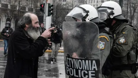 AFP A priest argues with riot police during a demonstration against the agreement with Skopje to rename neighbouring country Macedonia as the Republic of North Macedonia, on January 20, 2019 in Athens