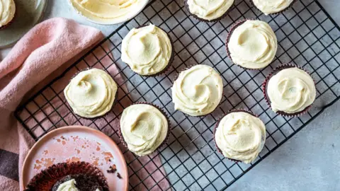 Irish stout cupcakes topped with creamy white chocolate and Irish cream frosting on a tray