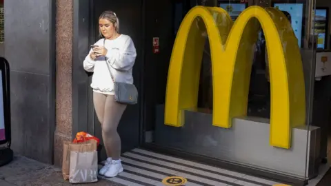 Getty Images Woman stood outside a McDonalds