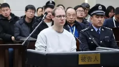 AFP/Getty Images Robert Lloyd Schellenberg (centre) listens during his retrial in Dalian's court. Photo: 14 January 2019