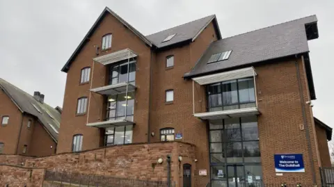 Shropshire Council A building containing a number of floors. It has a blue sign on the front with white writing saying Shropshire Council and "Welcome to The Guildhall".