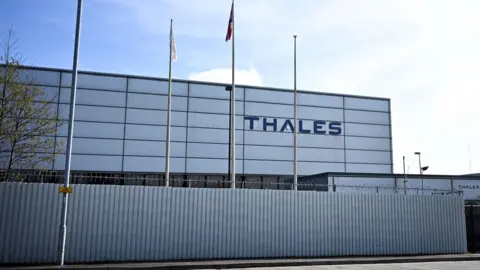 Getty Images The THALES factory in Belfast. A white corrugated iron building with THALES in blue on the building wall. 