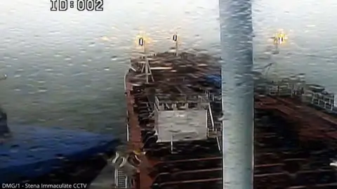 PA Media A still taken from CCTV showing a blue cargo ship hitting an oil tanker side on. The picture is grainy.