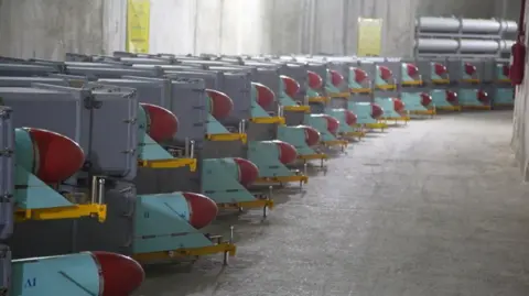 Missiles sit on trailers inside a concrete bunker.